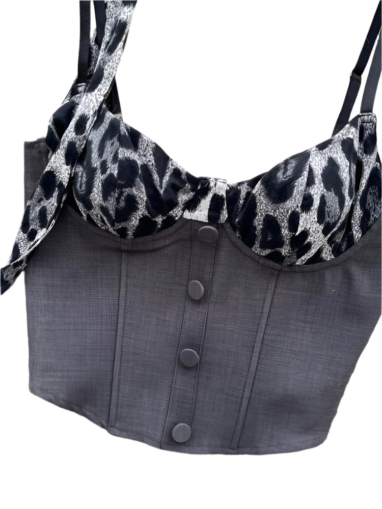 Gray corset with leopard print trim on a textured surface