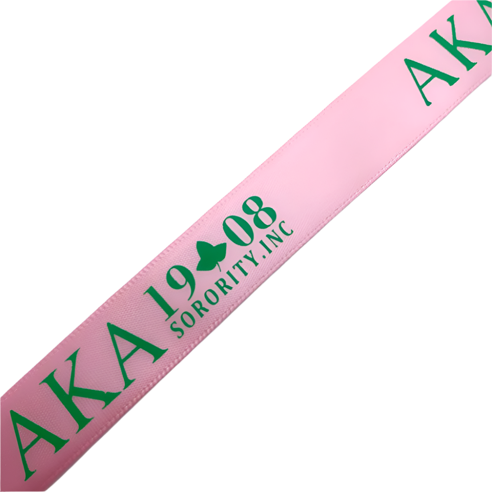 Pink sash with green text 'AKA 1908 Sorority, Inc.' on a light blue background