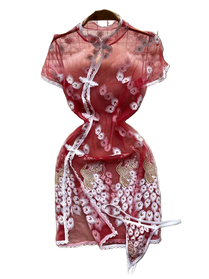 Red lace dress on a white fur surface with floral decorations in the background