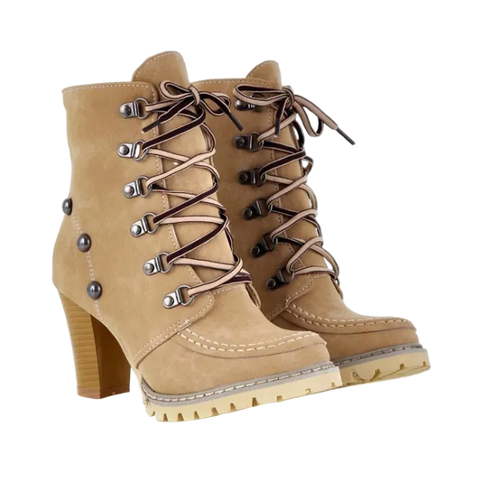 A pair of beige suede lace-up ankle boots with a chunky block heel, silver metal eyelets, and brown laces, shown on a white background.