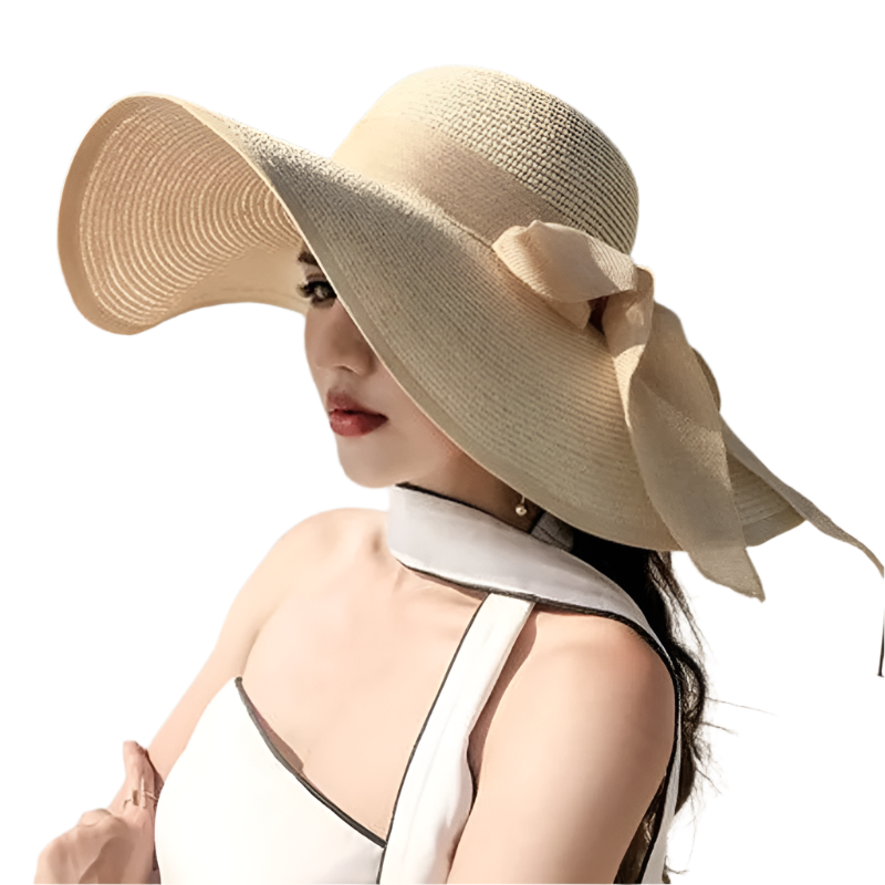 Woman wearing a large beige sun hat with a bow on a beach