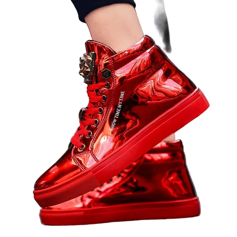 A pair of shiny metallic red high-top sneakers with decorative metal eyelets and white text reading 'STAY IN MY TIME' on the side, shown worn with one shoe lifted over the other on an outdoor street background.