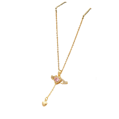 Gold necklace with a heart pendant in an open green jewelry box on a beige fabric background