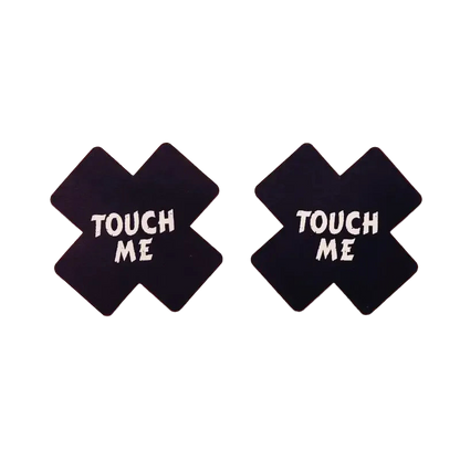 Black 'TOUCH ME' signs with crosses on a pink background
