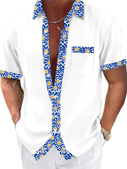 White shirt with blue floral patterns worn by a person on a beach.