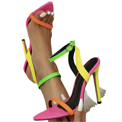 Colorful high-heeled sandals with neon straps on a white fur surface.