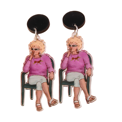 Earrings with a design of a person in a pink sweater sitting on a chair, on a beige background.