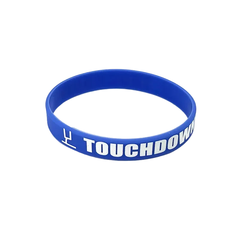 A blue silicone wristband with white text reading 'TOUCHDOWN' and a white symbol, photographed on a plain white background.