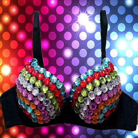 A black bra-style costume top covered with rows of colorful rhinestones in red, blue, green, purple, orange, and clear, shown against a neon disco ball background.