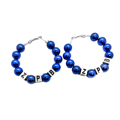 Pair of blue beaded hoop earrings with letter beads on a white background