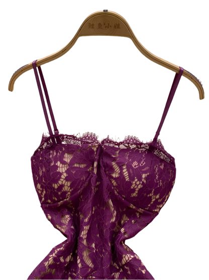 Purple lace dress on a hanger against a white textured background