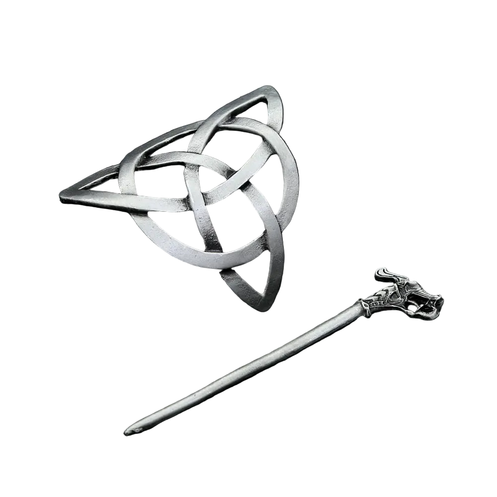 Silver Celtic knot brooch and hairpin on a dark textured surface