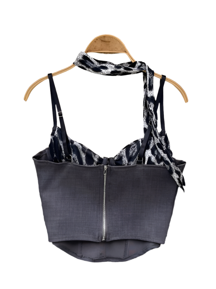 Black tank top with tie detail on a hanger against a floral and textured background