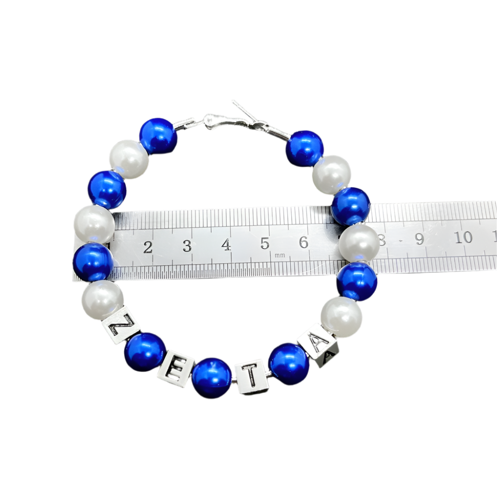Bracelet with blue and white beads and letter beads on a gray background