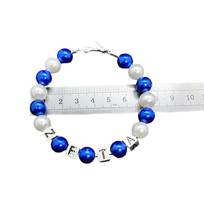 Bracelet with blue and white beads and letter beads on a gray background