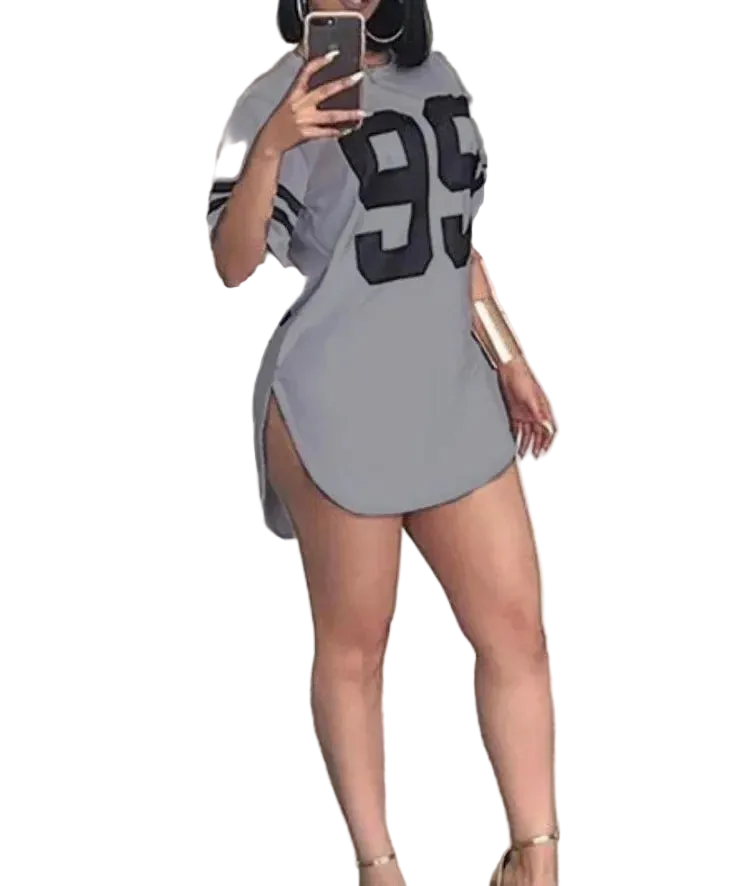 Person wearing a gray dress with large black numbers, taking a mirror selfie.