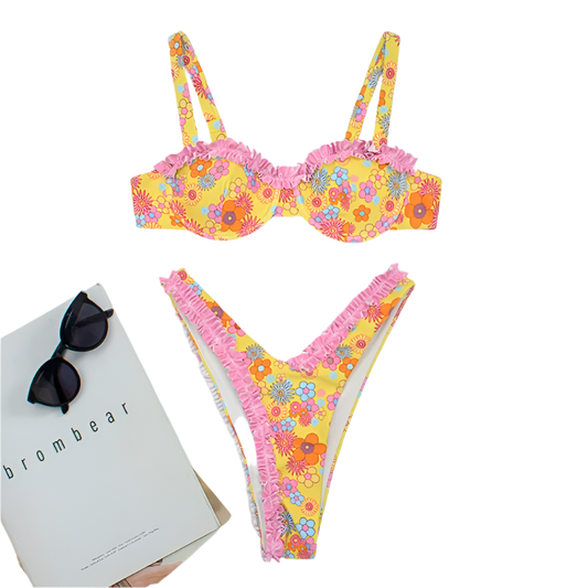 A vibrant bikini set with a yellow floral pattern and pink ruffle trim. The top has structured cups and adjustable straps, while the bottom features a high-cut design.