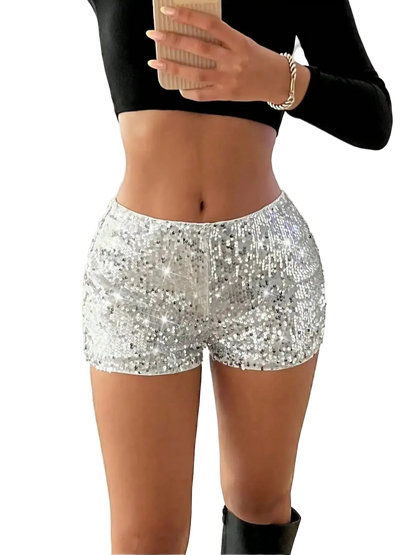 Person wearing silver sequin shorts and a black top indoors.