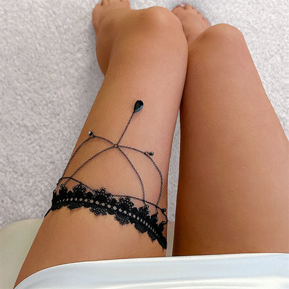 Black lace leg accessory worn by a person on a textured surface