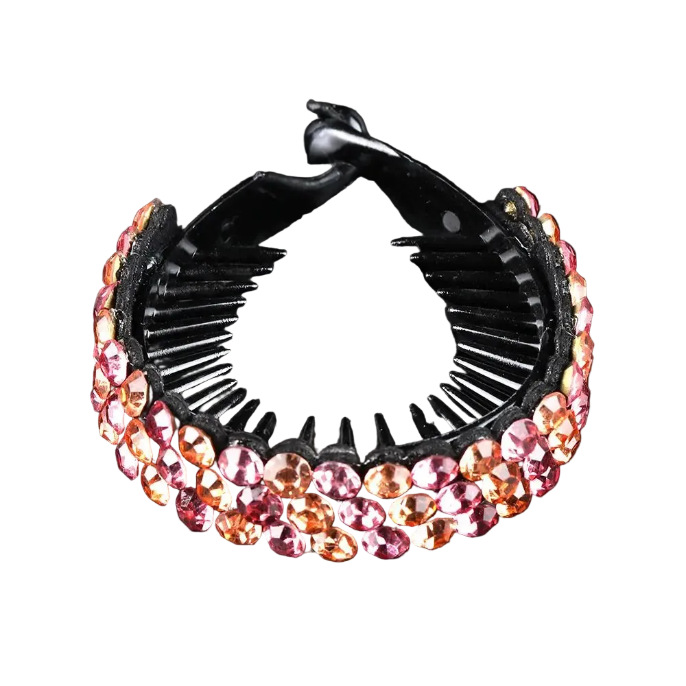 A black hair claw clip embellished with rows of faceted pink and orange rhinestones, displayed on a reflective black surface.