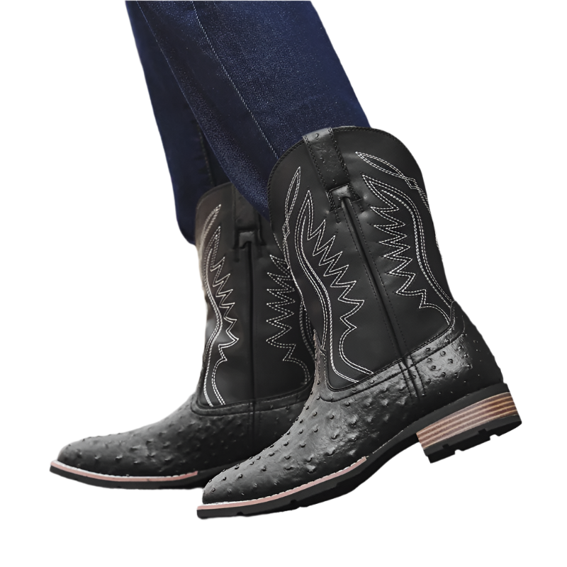 Black cowboy boots with detailed design on a blurred background