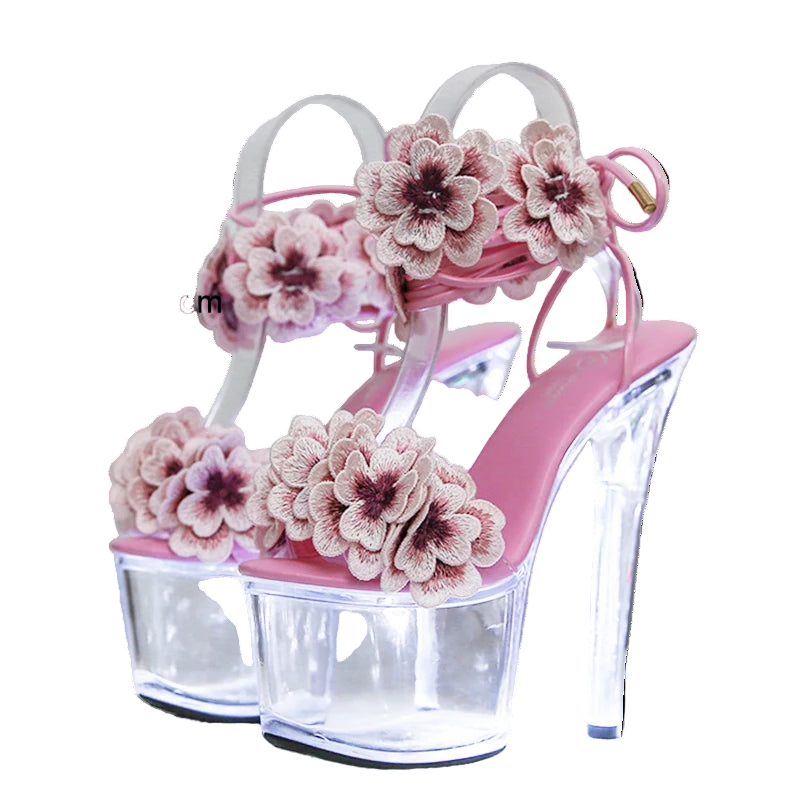 Pink high-heeled sandals with floral designs on a white background