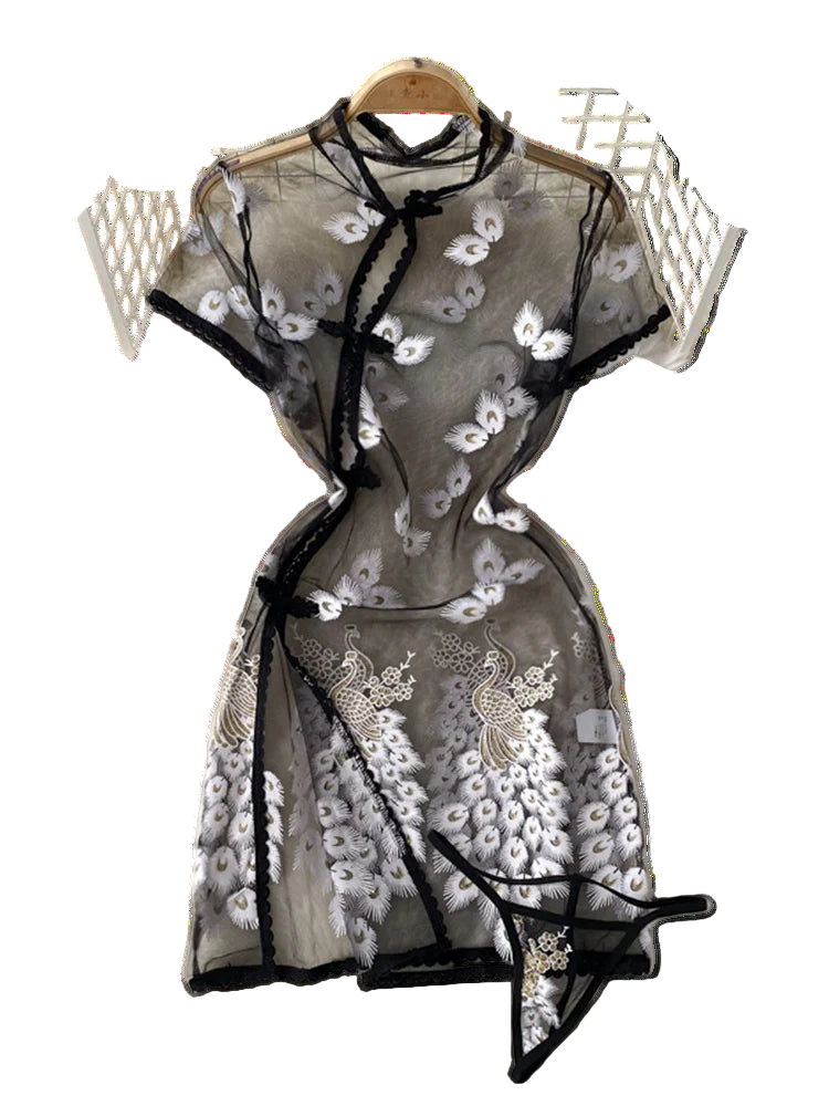 Black lace dress with floral embroidery on a white textured surface