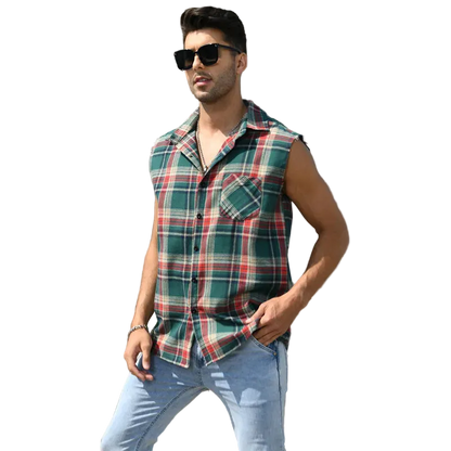 Man wearing a plaid sleeveless shirt and sunglasses standing on steps in front of a building.