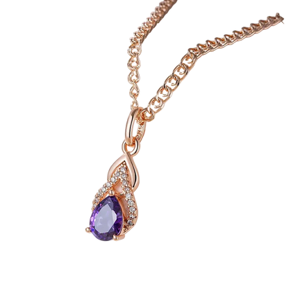 Rose gold necklace with a purple teardrop pendant on a white stand.
