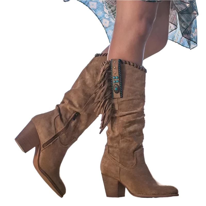Brown suede boots with fringe and turquoise details worn by a person against a blue sky.