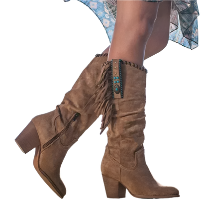 Brown suede boots with fringe and turquoise details worn by a person against a blue sky.