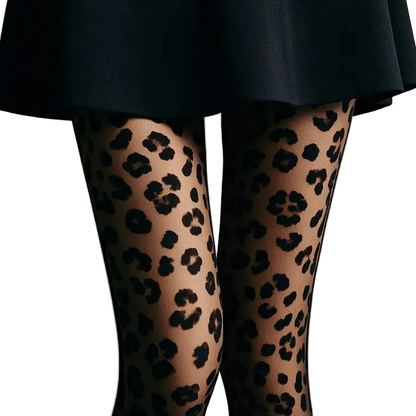 Close-up of a person's legs wearing sheer black leopard-print tights, paired with a dark skirt against a plain light gray background.