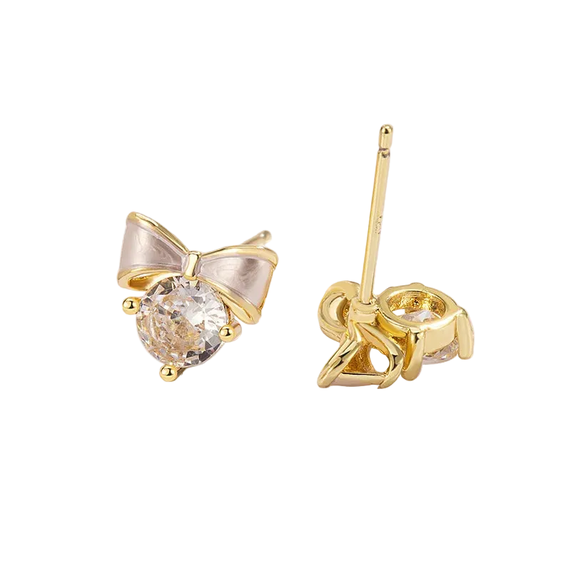 A pair of gold stud earrings featuring a bow-shaped setting with a clear round gemstone, shown on a clean white background with one earring facing forward and the other showing the back post.