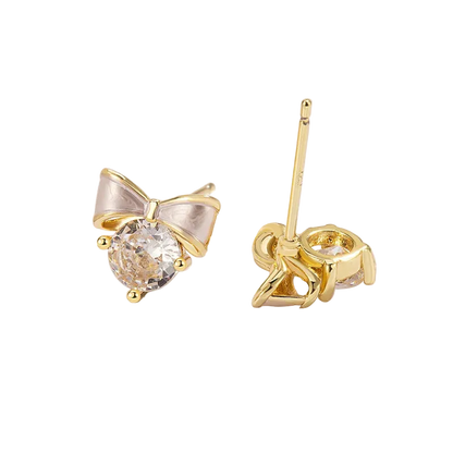 A pair of gold stud earrings featuring a bow-shaped setting with a clear round gemstone, shown on a clean white background with one earring facing forward and the other showing the back post.