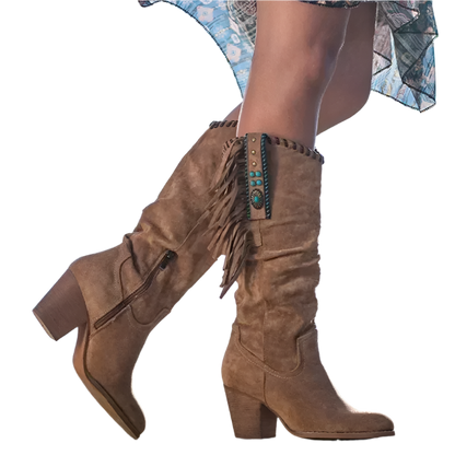 Brown suede knee-high boots with fringe and turquoise details worn by a person against a blue sky.