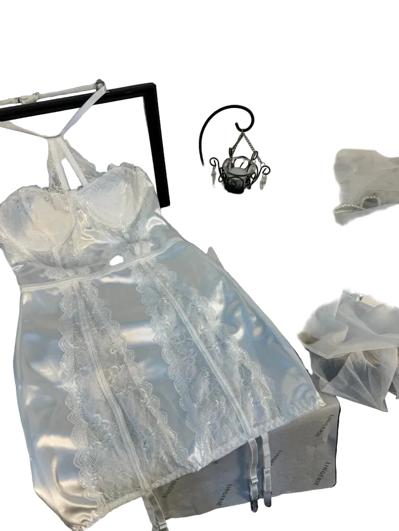 White lace dress on a hanger with a mirror and decorative items in the background.