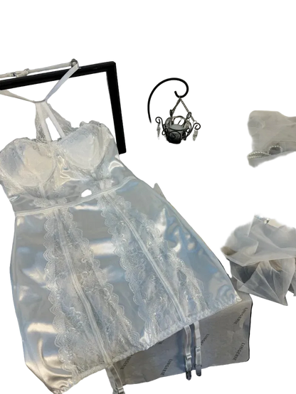 White lace dress on a hanger with a mirror and decorative items in the background.