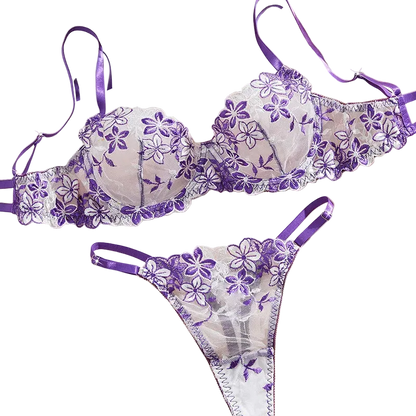 Purple floral lingerie set on a soft pink background with flowers.