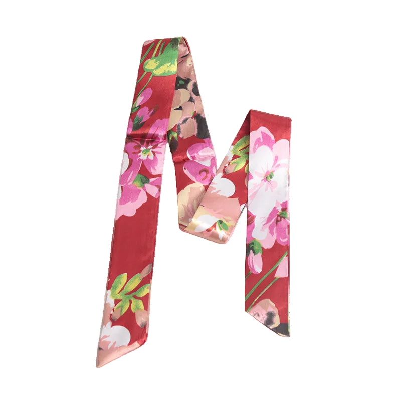 Two floral-patterned scarves on a white surface with a magazine underneath.
