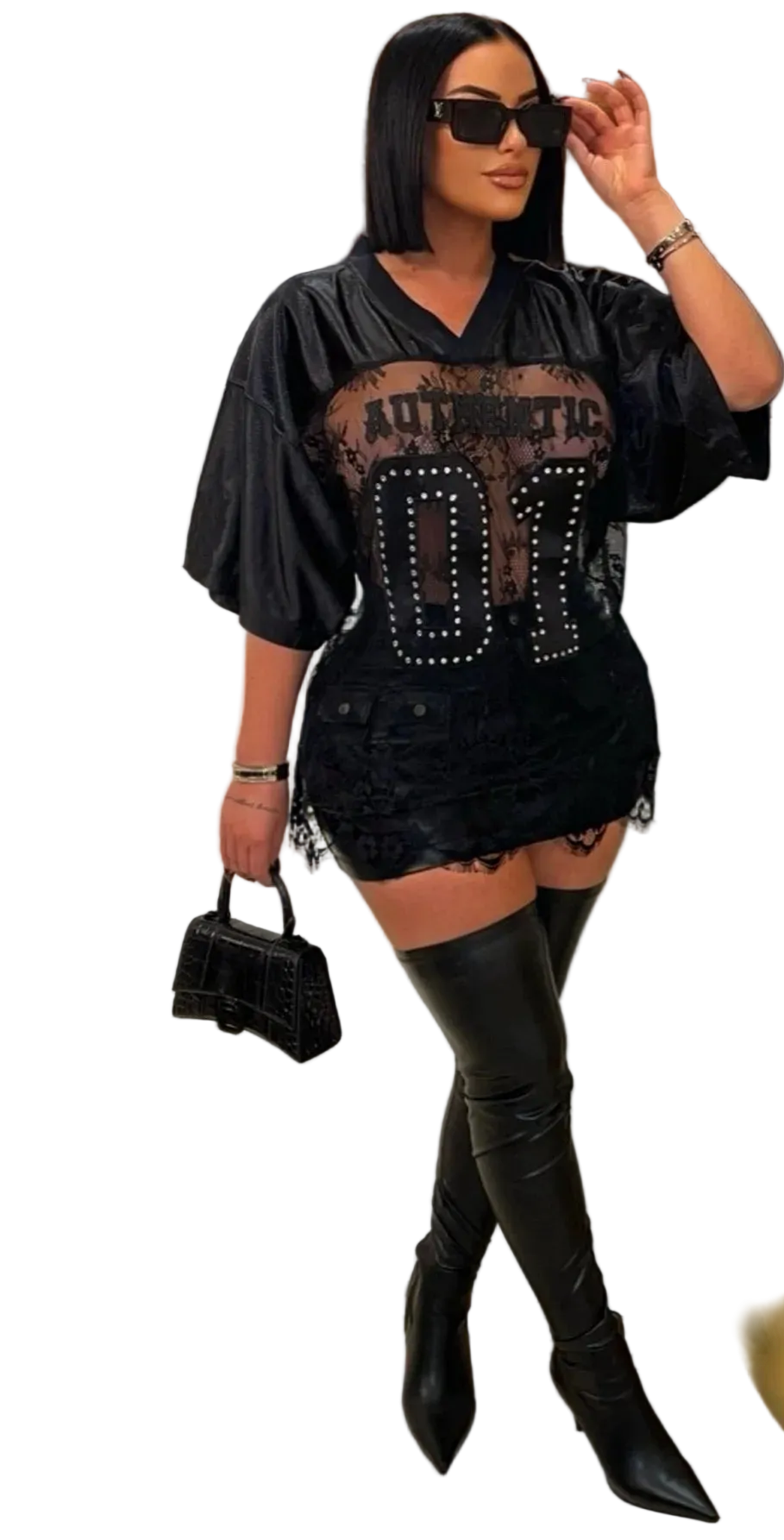 Woman in a stylish black outfit with studded details, standing in a room with a gold decorative mirror.