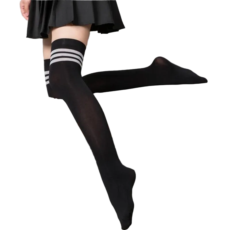 Person wearing black knee-high socks with white stripes sitting on a gray couch.