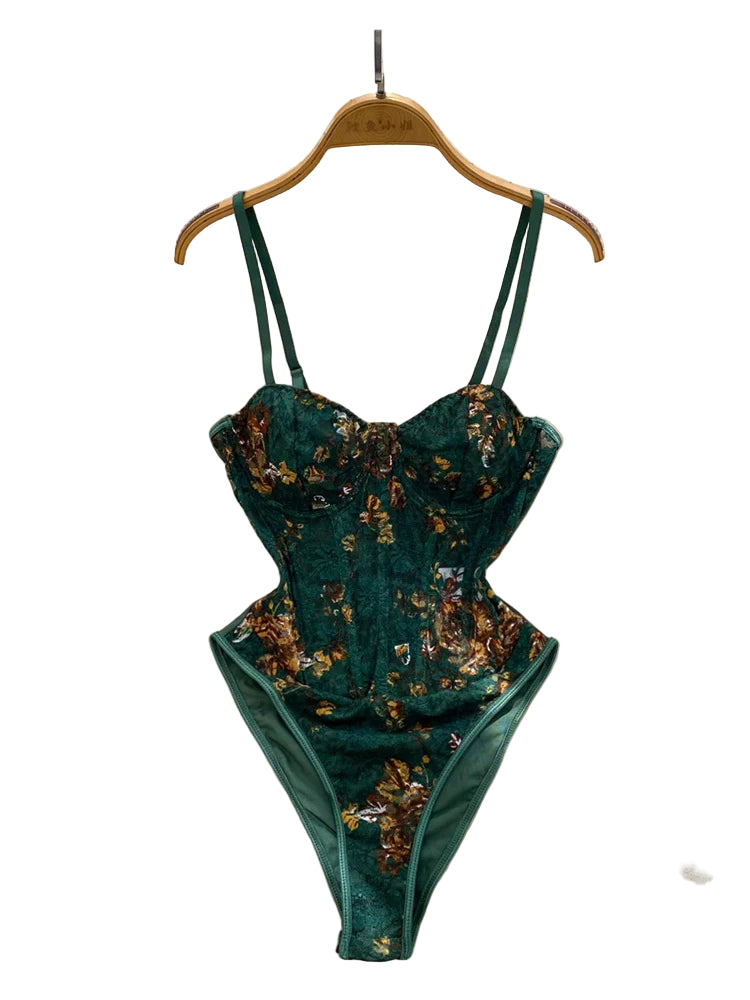 Teal floral lingerie set on a hanger with a white fur surface and decorative background.