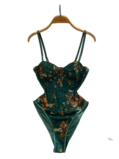 Teal floral lingerie set on a hanger with a white fur surface and decorative background.