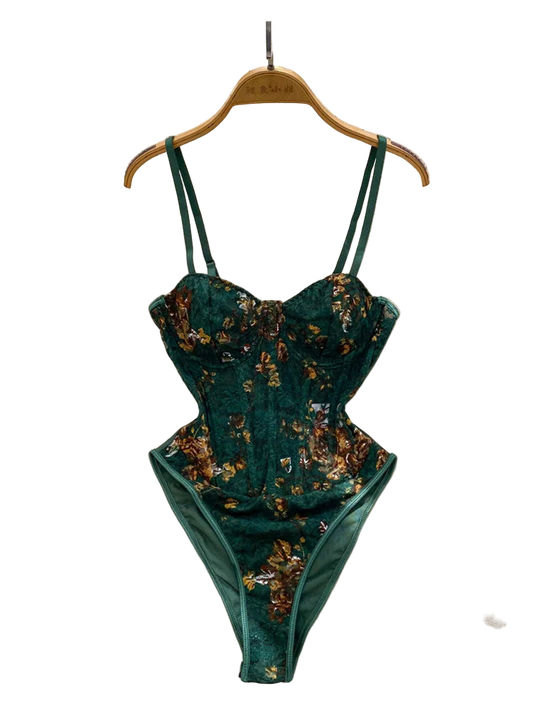 Teal floral lingerie set on a hanger with a white fur surface and decorative background.
