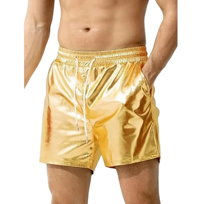 A man wearing shiny metallic gold drawstring shorts against a plain white background.