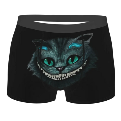 boxer shorts featuring the Cheshire Cat design from Alice in Wonderland, with glowing turquoise eyes and distinctive grinning teeth illuminated against a dark background.