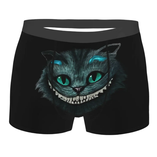 boxer shorts featuring the Cheshire Cat design from Alice in Wonderland, with glowing turquoise eyes and distinctive grinning teeth illuminated against a dark background.