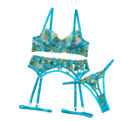 Blue floral lingerie set on a white surface with flowers and a box in the background