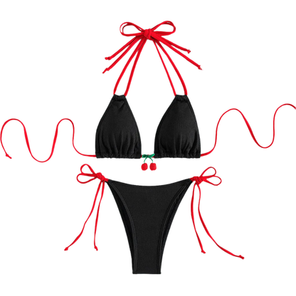 A black bikini with red string ties and cherry embellishments on the top. The design is simple yet charming, with a touch of whimsy.
