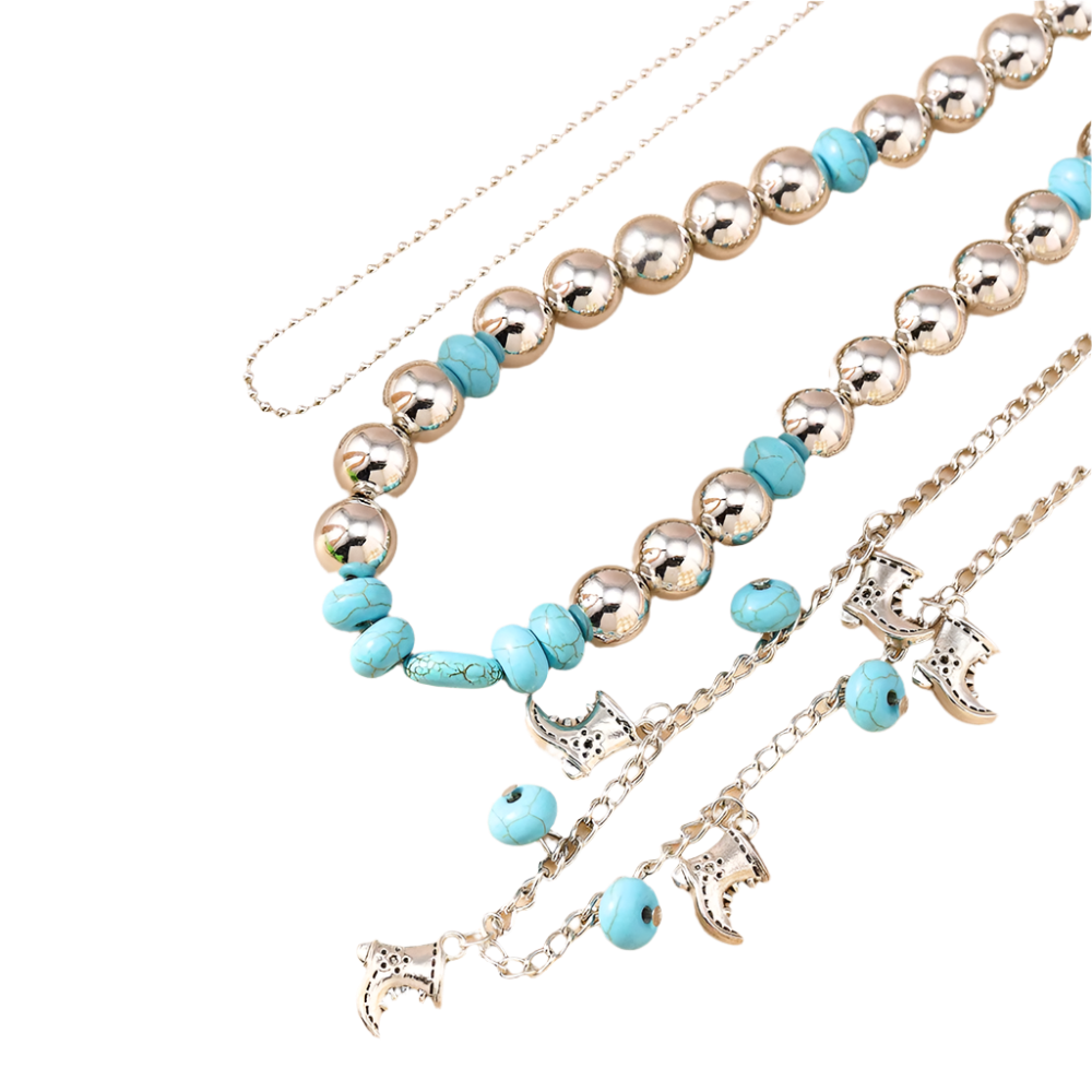 Necklace with blue beads and silver charms on a beige surface